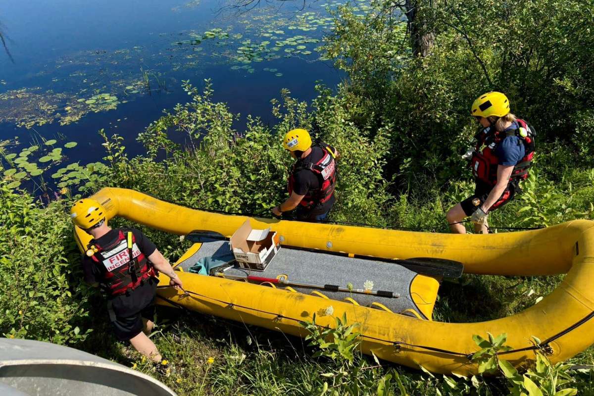 Rescuers taking a boat into the water.