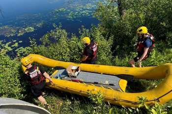 Rescuers taking a boat into the water.