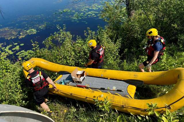 Rescuers taking a boat into the water.