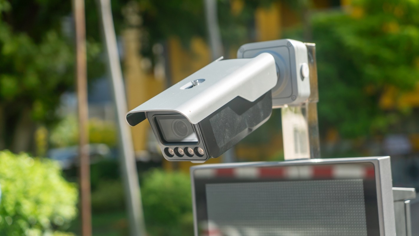 A security camera mounted on a pole in an outdoor area.
