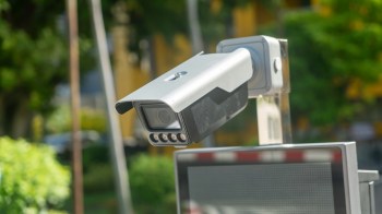 A security camera mounted on a pole in an outdoor area.