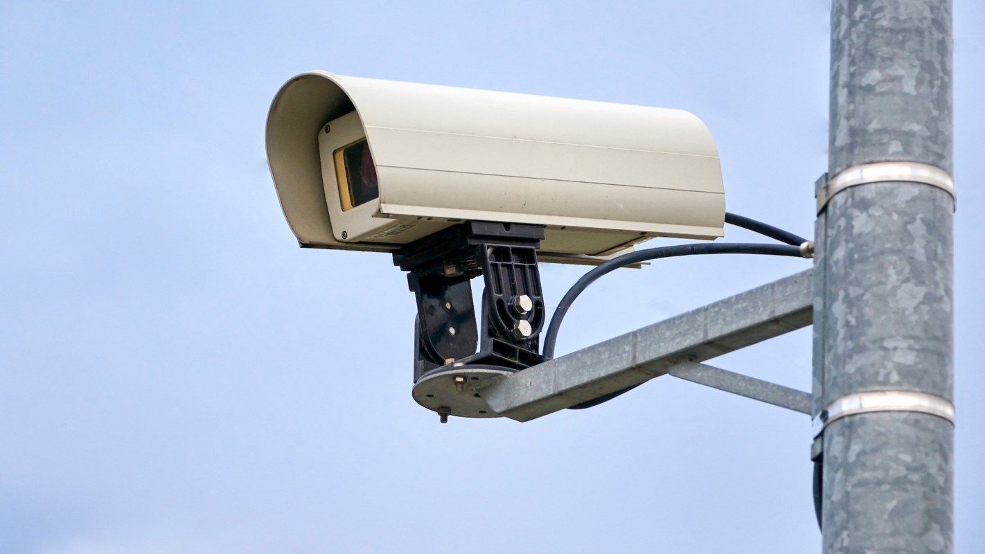 A surveillance camera on a metal pole.