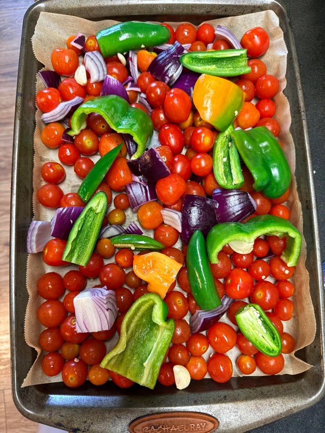 A tray filled with vegetables for cherry tomato salsa.