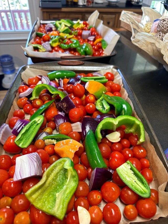 Two trays filled with vegetables for cherry tomato salsa.
