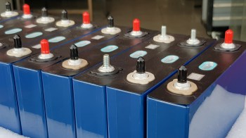 A row of batteries with various colored terminals on a black surface.