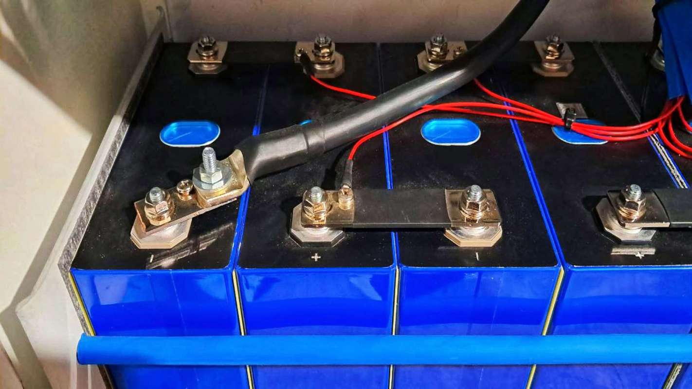 A close-up of several battery cells with metal terminals and wiring connections.