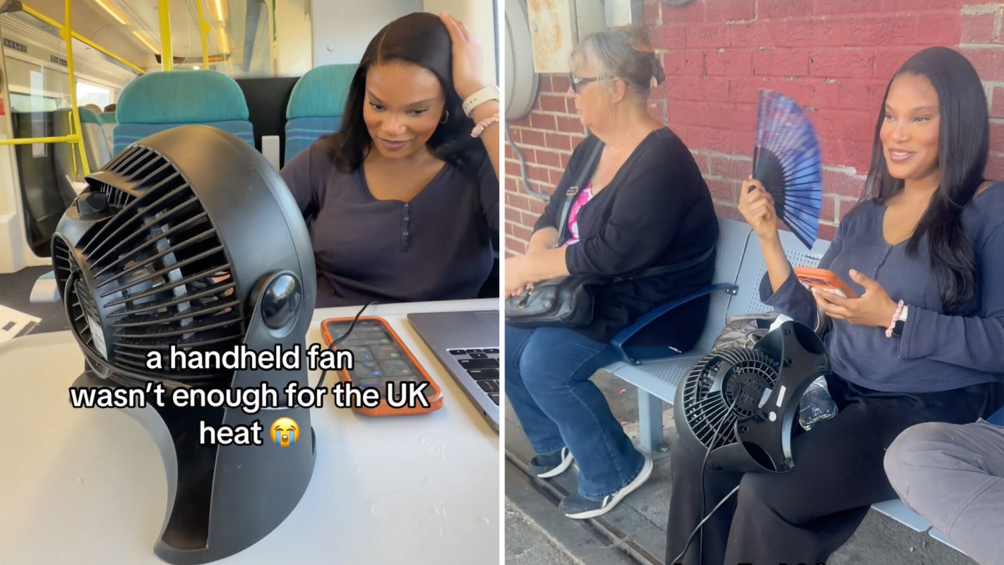 A woman uses a handheld fan while sitting next to another woman at a bus stop, with a small fan on the ground.