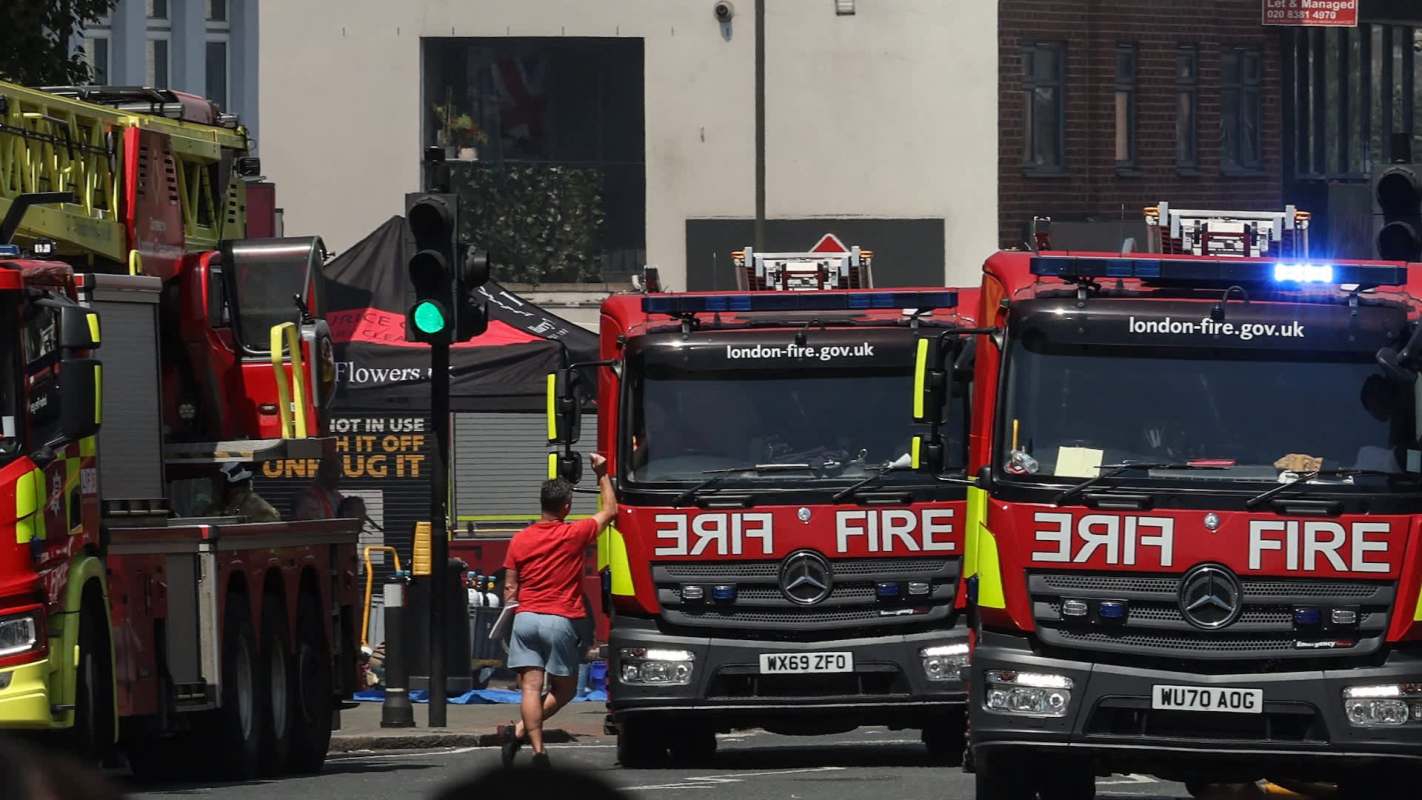 Three fire trucks parked on the street.