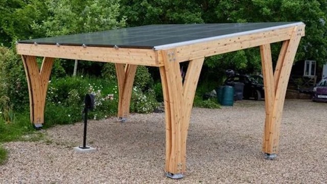 A wooden structure with a solar panel roof in a garden setting.