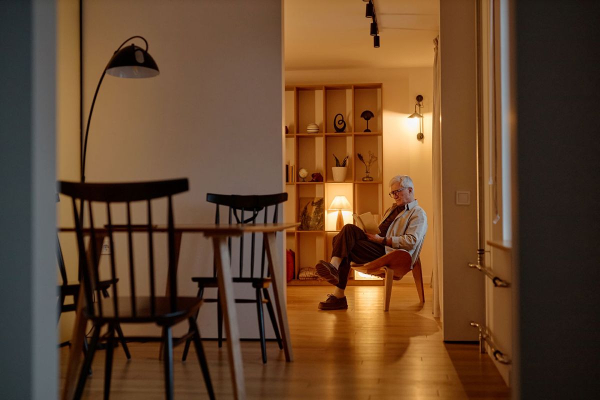A man sitting on a chair surrounded by lamps.