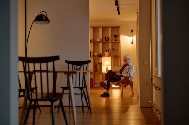 A man sitting on a chair surrounded by lamps.