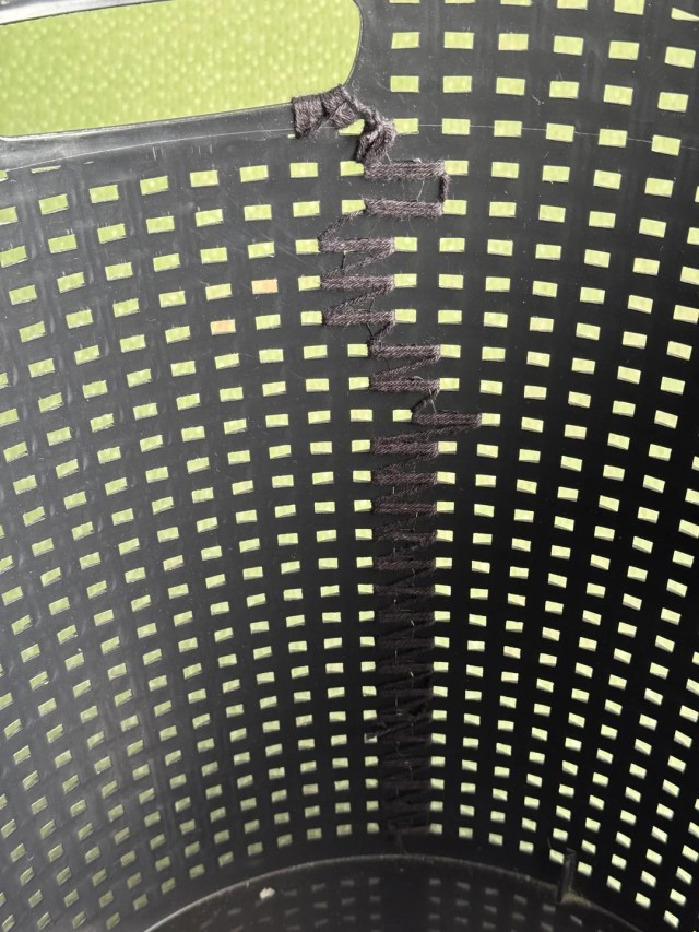 A split basket tied together with yarn.