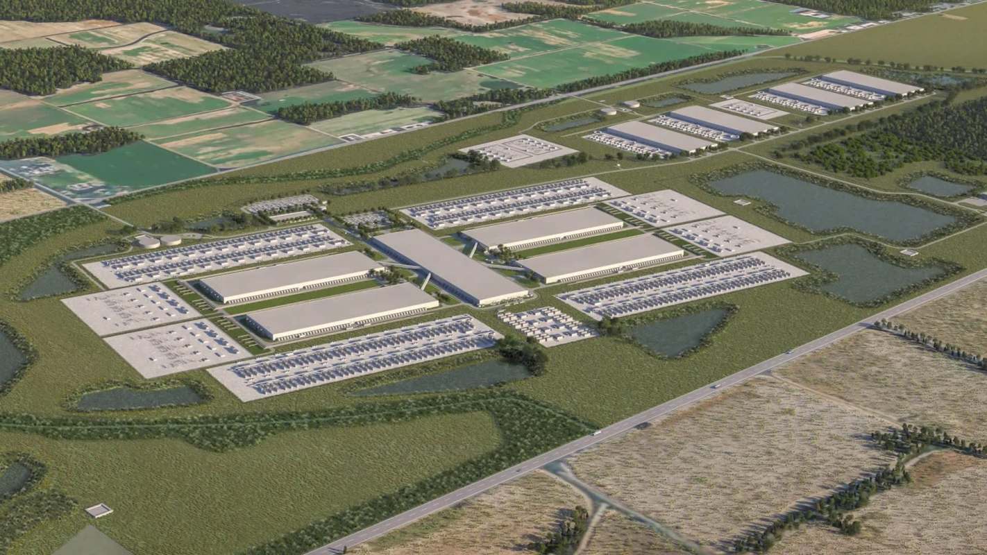 An aerial view of a data center complex surrounded by fields and greenery.