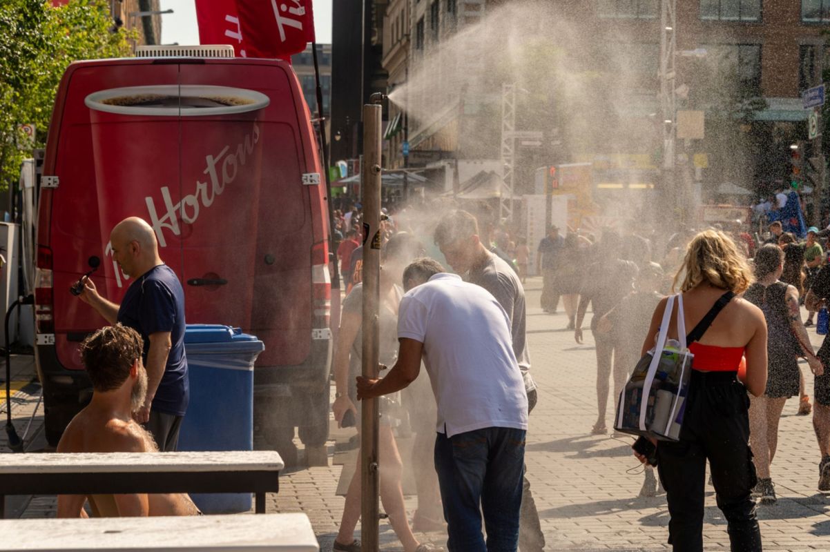 People using a misting system during a heat wave.