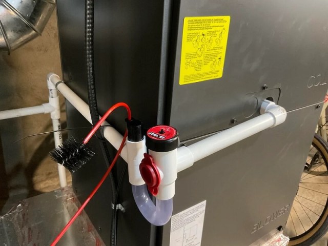 A mechanical setup with pipes, valves, and a brush connected to a machine in an underground environment.