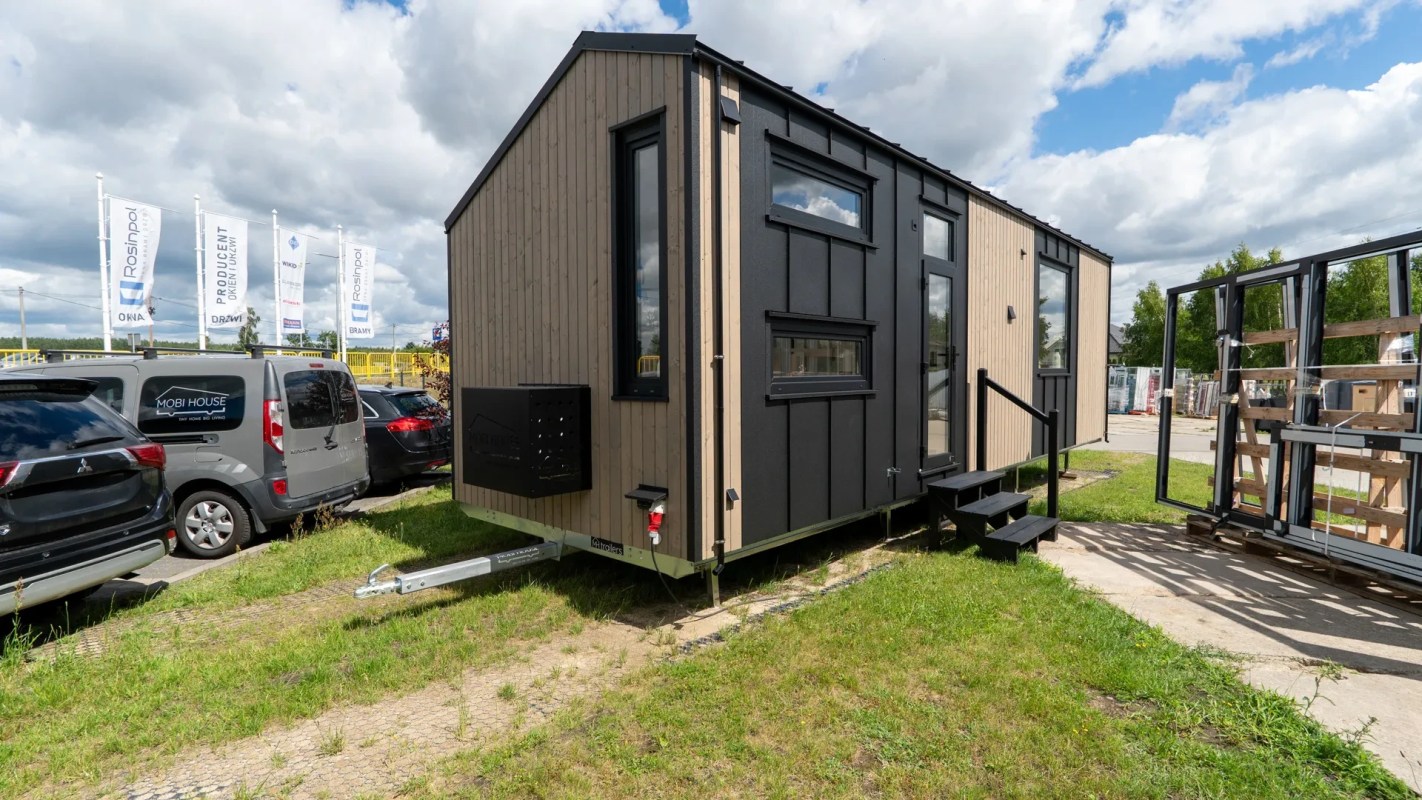 A modern tiny house with black and wood paneling.