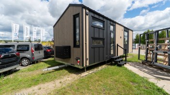 A modern tiny house with black and wood paneling.