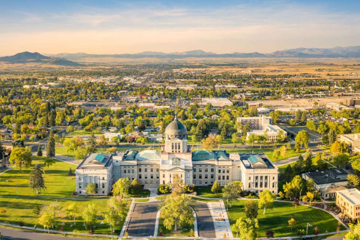 Aerial view of a city landscape with a historic building and surrounding greenery.
