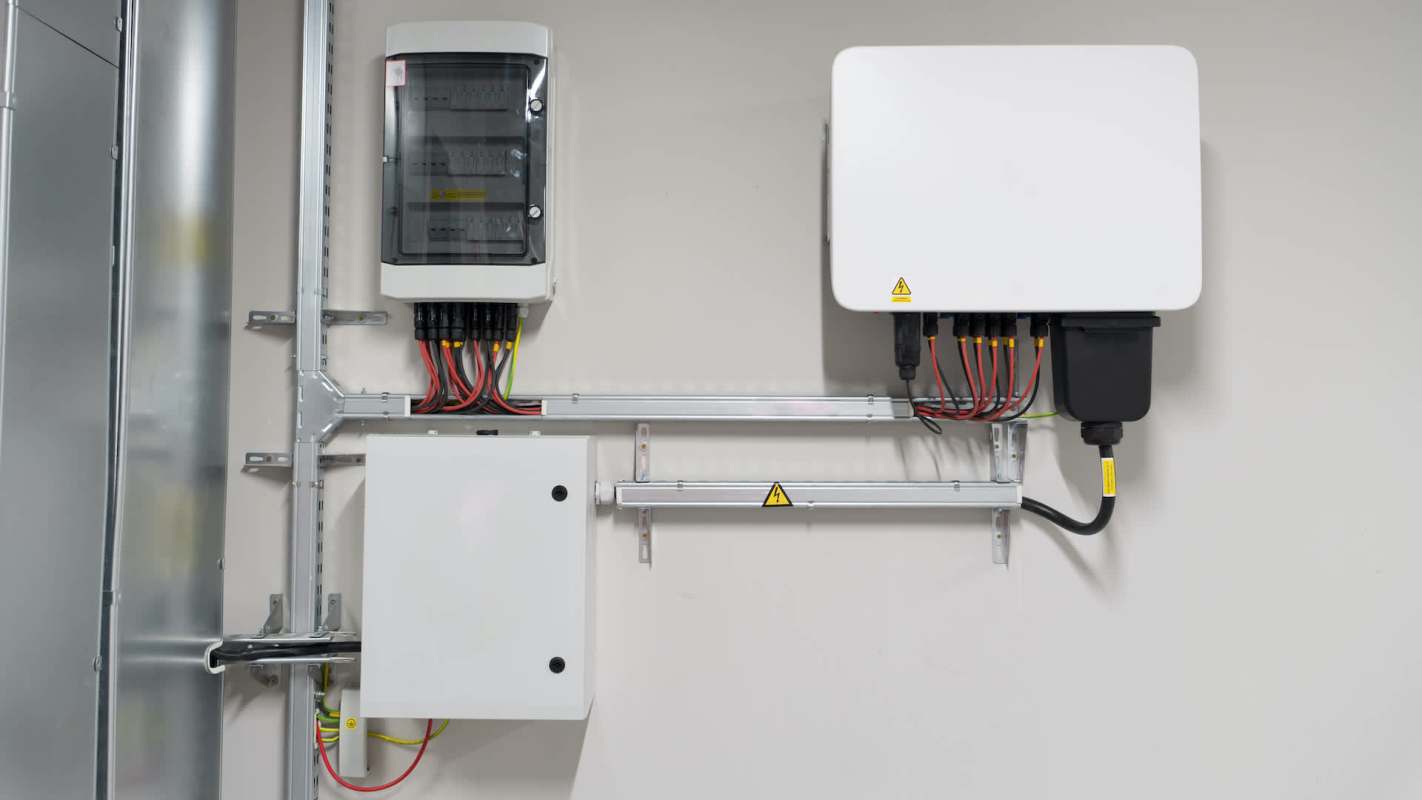 Two electrical panels mounted on a wall with various wires and connectors.