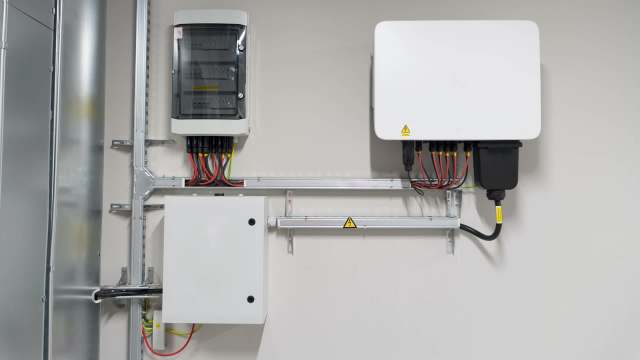 Two electrical panels mounted on a wall with various wires and connectors.
