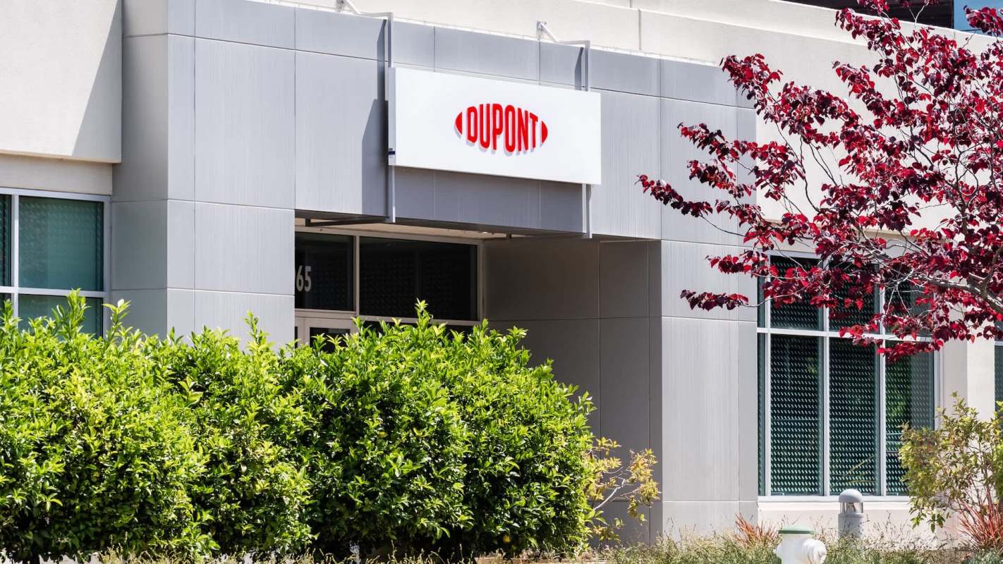 A building exterior with a sign that reads "DUPONT" and green shrubbery nearby.