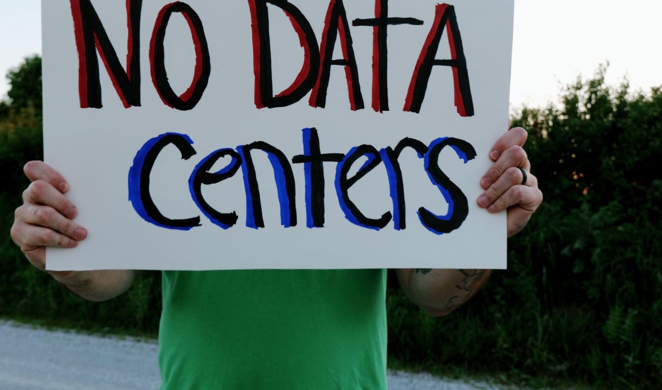 A person holding a "no data centers" sign.