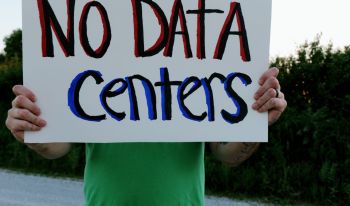 A person holding a "no data centers" sign.