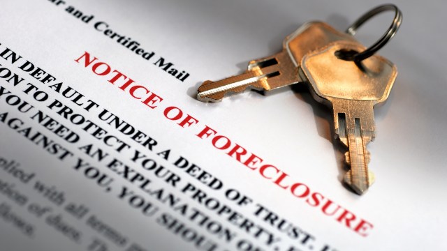 A foreclosure notice with two keys lying on top.