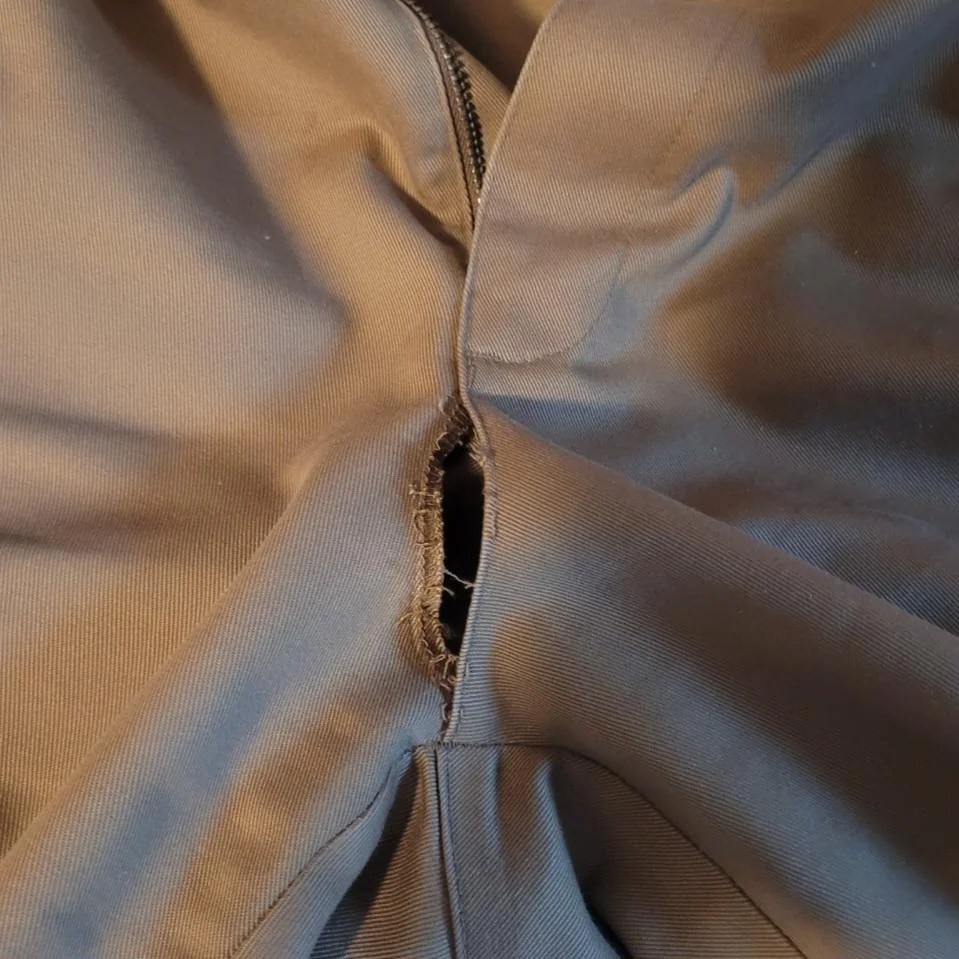A hole in a beige garment.