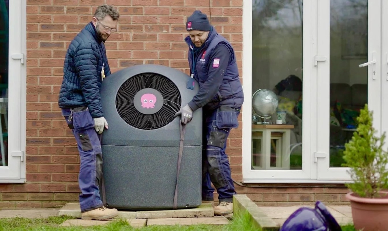 Two technicians installing an outdoor heat pump from Octopus Energy.