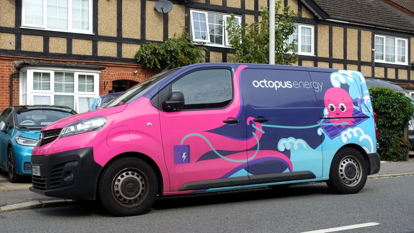 A pink and blue van with an octopus graphic and the logo "octopus energy" parked by a residential area.