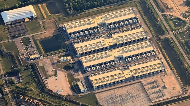 An aerial view of a large industrial complex with several buildings and surrounding green areas.