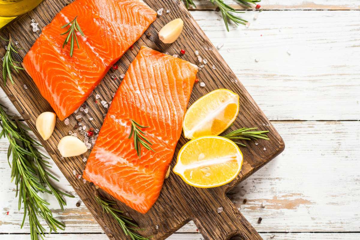 Salmon fillets on a wooden cutting board.