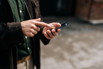 A person holding and looking at a cellphone.