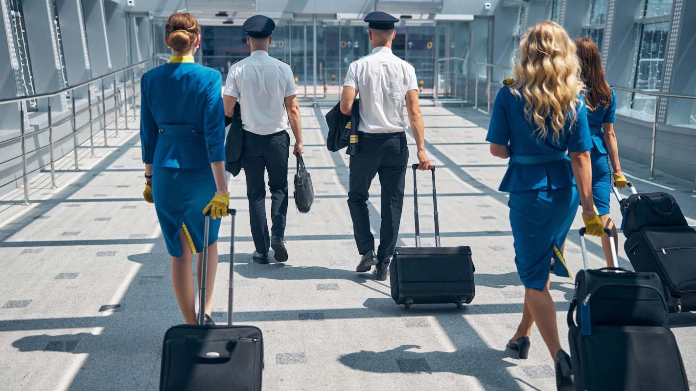 Airline staff walking with suitcases.