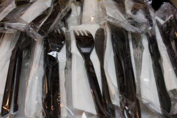 A pile of plastic knives and forks.