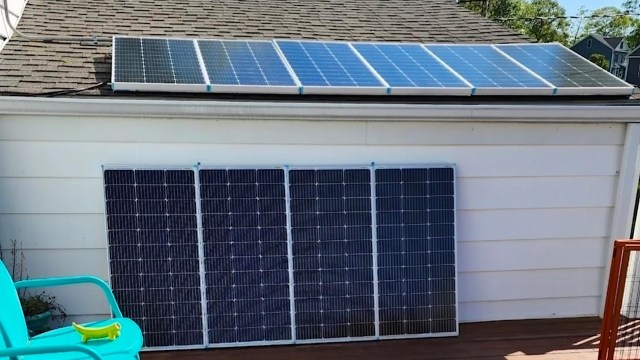 Solar panels installed on a roof and a wall, with a green chair and toy in the foreground.