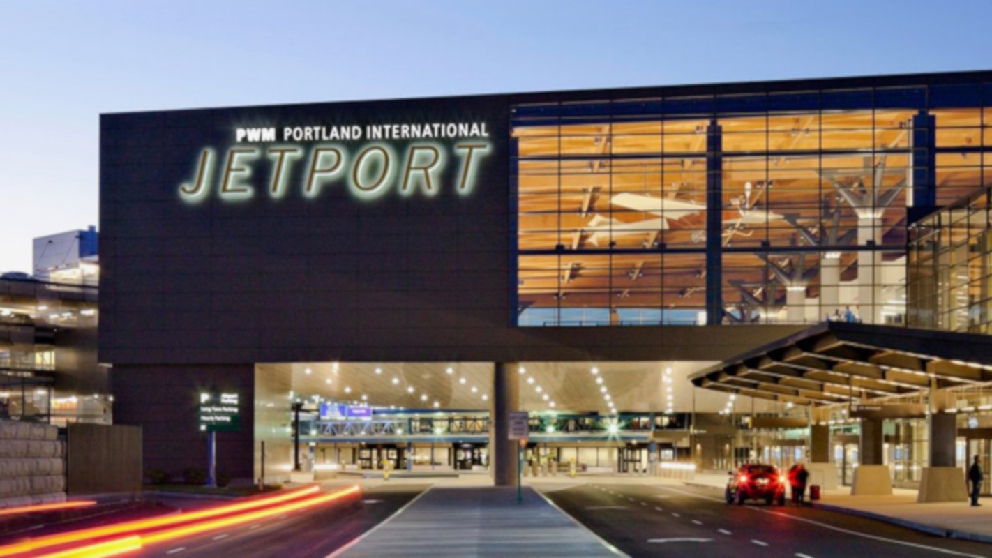 Portland International Jetport building with large windows and illuminated signage.