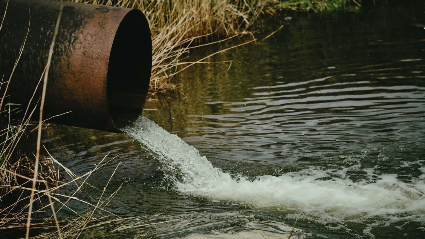 A rusty pipe discharging wastewater.
