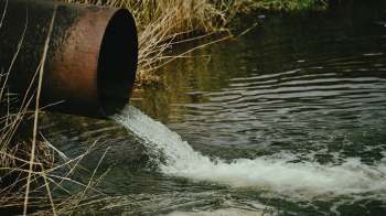 A rusty pipe discharging wastewater.