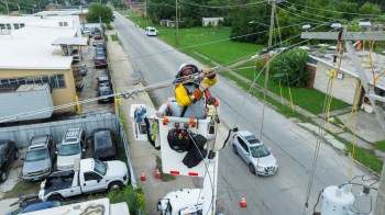 worker fixing power line after storm