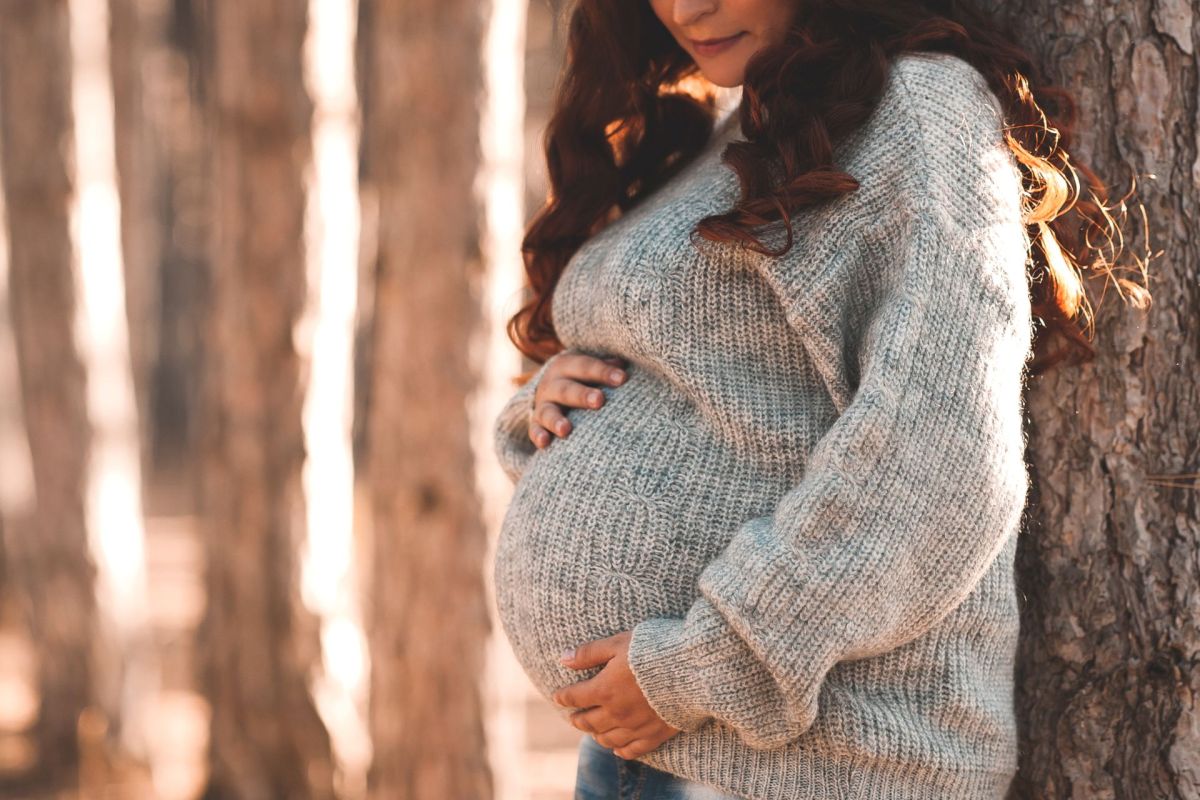 A pregnant person holding their belly.