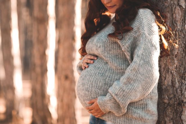 A pregnant person holding their belly.