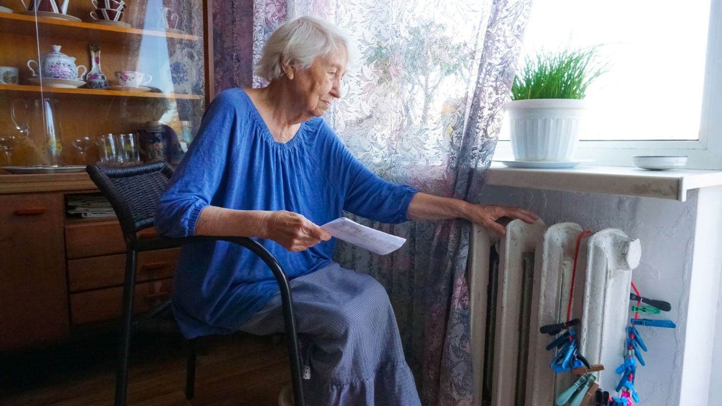 A woman sitting in front of a radiator.