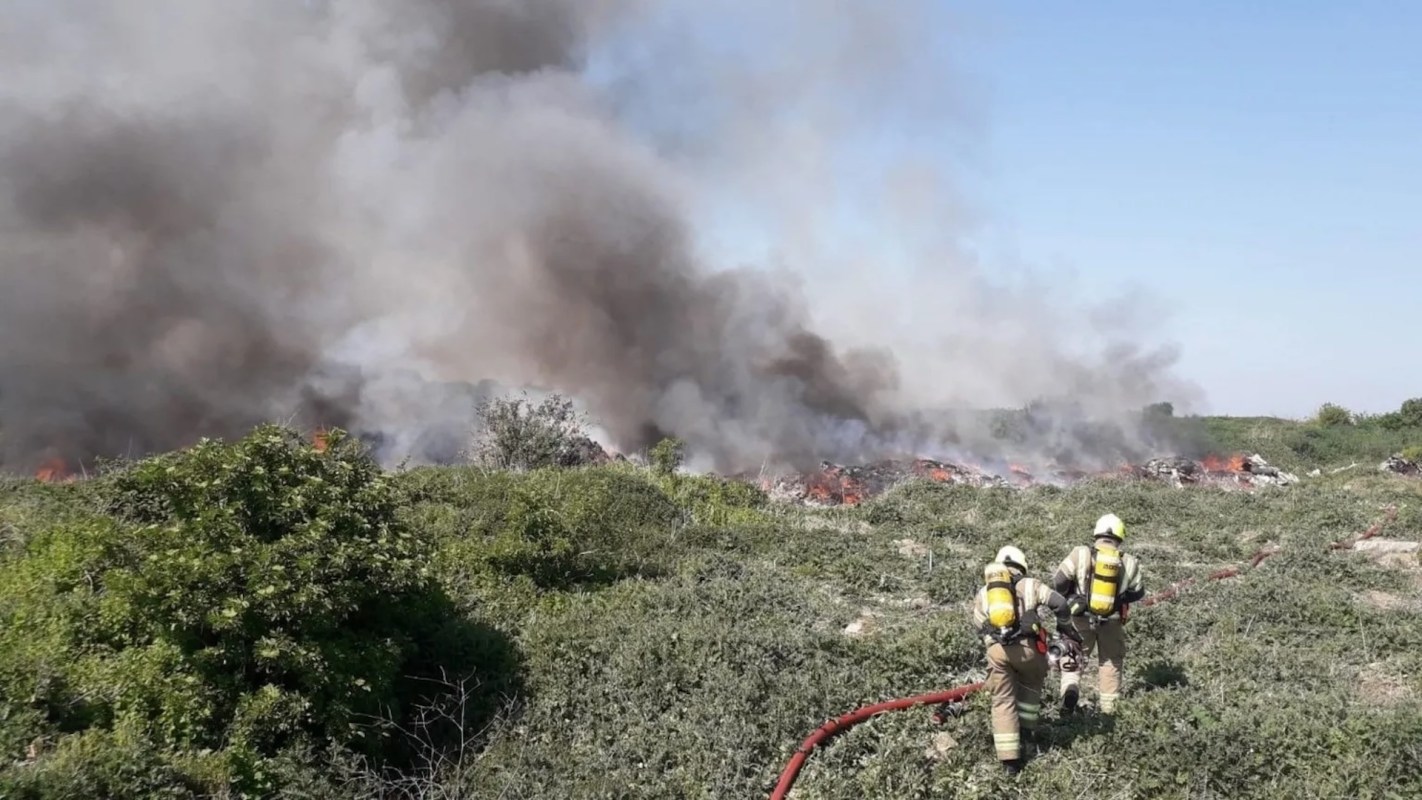 Firefighters working to control a large fire.