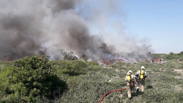 Firefighters working to control a large fire.