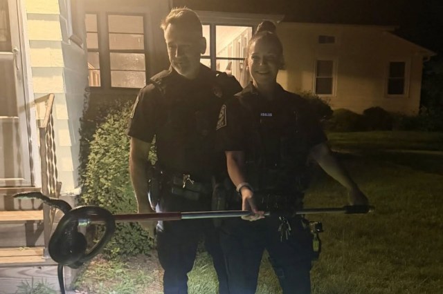 Officers removing a ratsnake from a home.