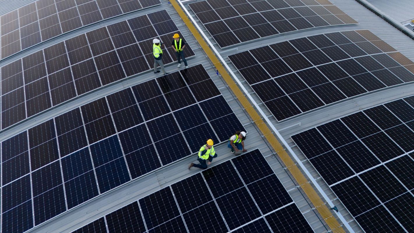 Engineers installing solar panels on top of a business.
