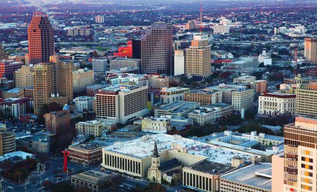 Aerial view of a cityscape featuring a mix of modern and historic buildings.