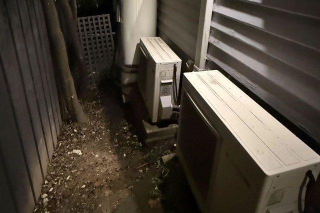 Two heat pumps alongside a house.